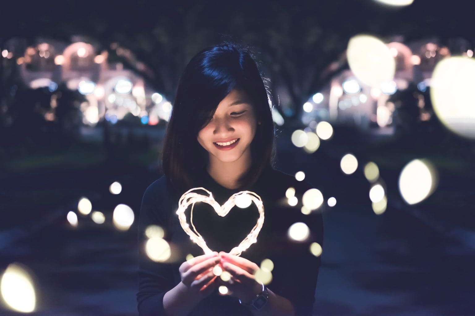 Girl holding light-up heart at night