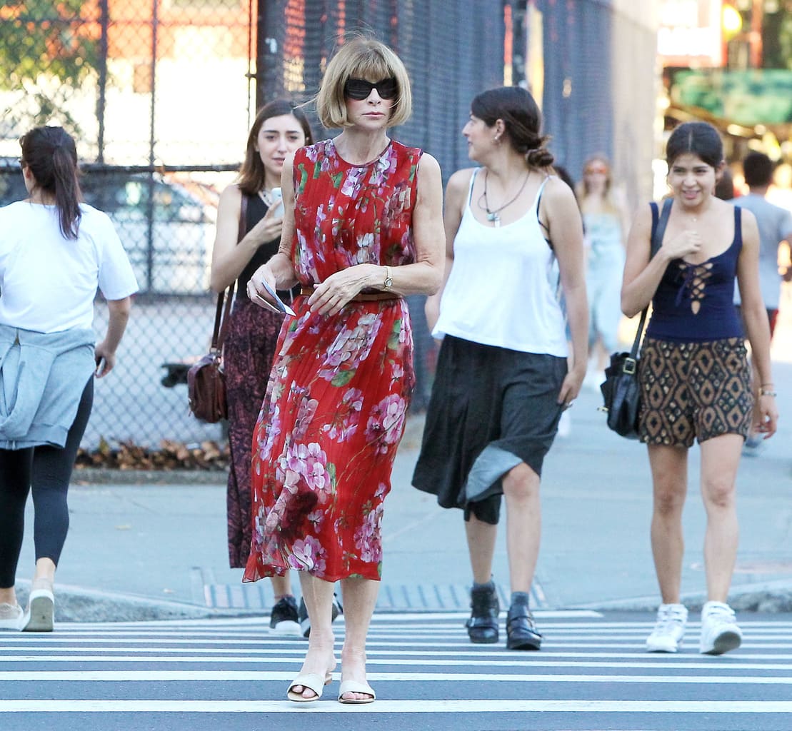 Anna Wintour wearing a red floral dress while crossing the street