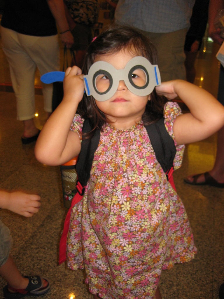 A little girl wearing a pair of paper glasses