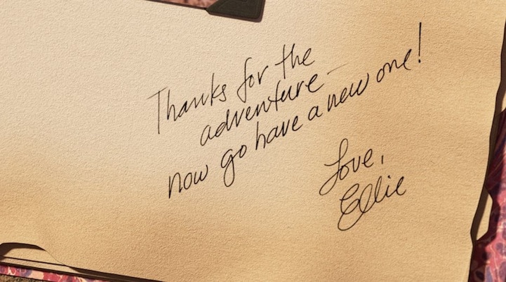 Screenshot from the movie "Up" of Ellie's handwriting in the Adventure Book reading 'thanks for the adventure - now go have a new one! love, ellie'