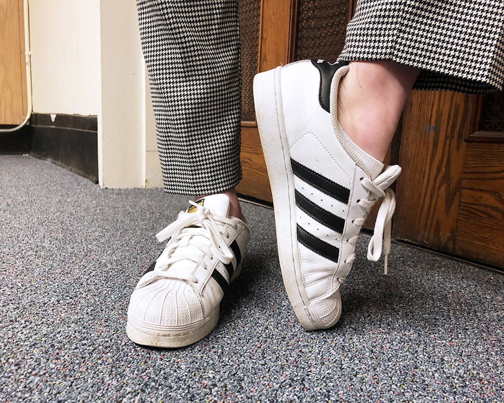 Rachel wears classic white Adidas Superstar sneakers.