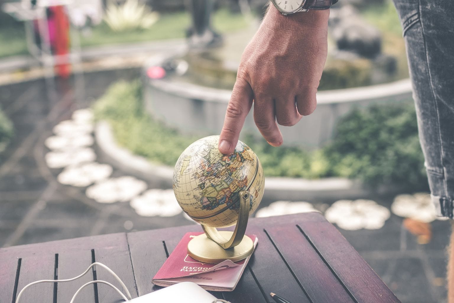 Person touching a globe with their finger.