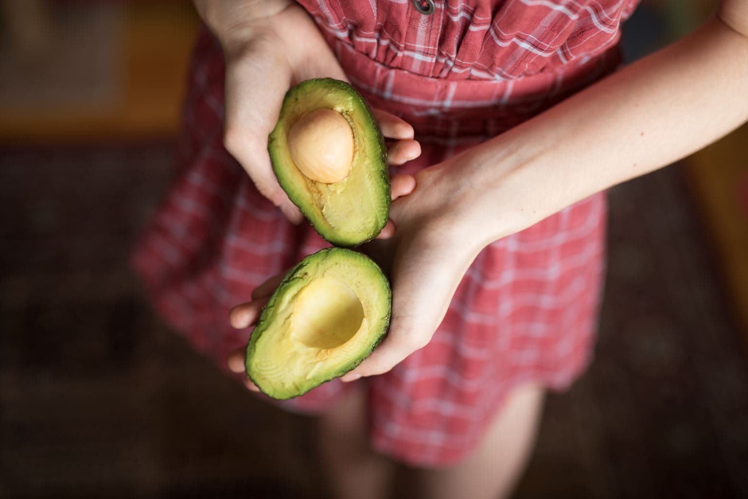 girl holding avocado