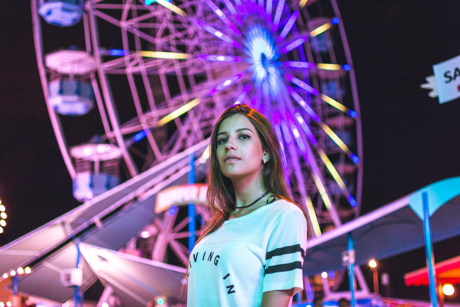 Girl at a summer music festival in front of a ferris wheel