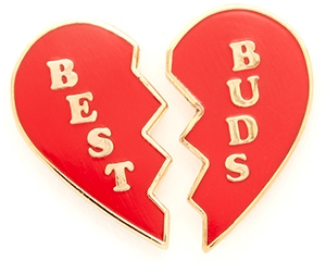 Two red-and-gold enamel pins, each shaped like half of a broken heart, with "BEST" on one pin and "BUDS" on the other