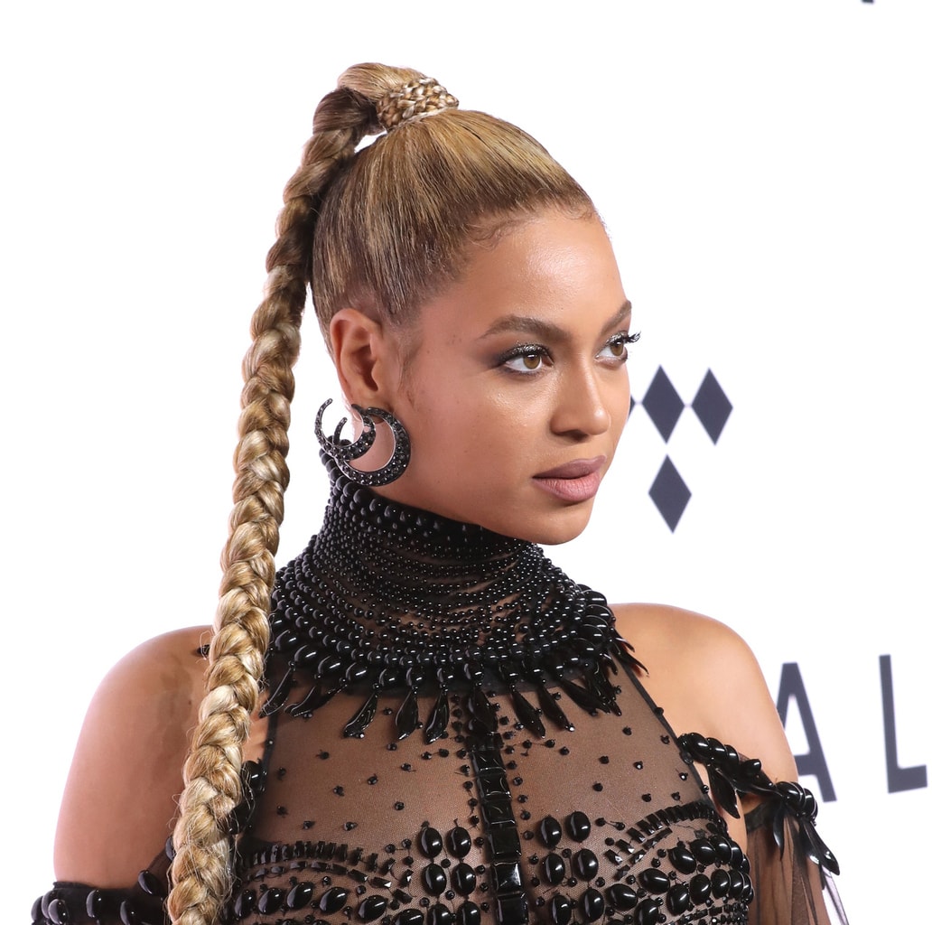 Beyonce rocking a black high neck gown, statement earrings, and a high ponytail at a Tidal event in 2016