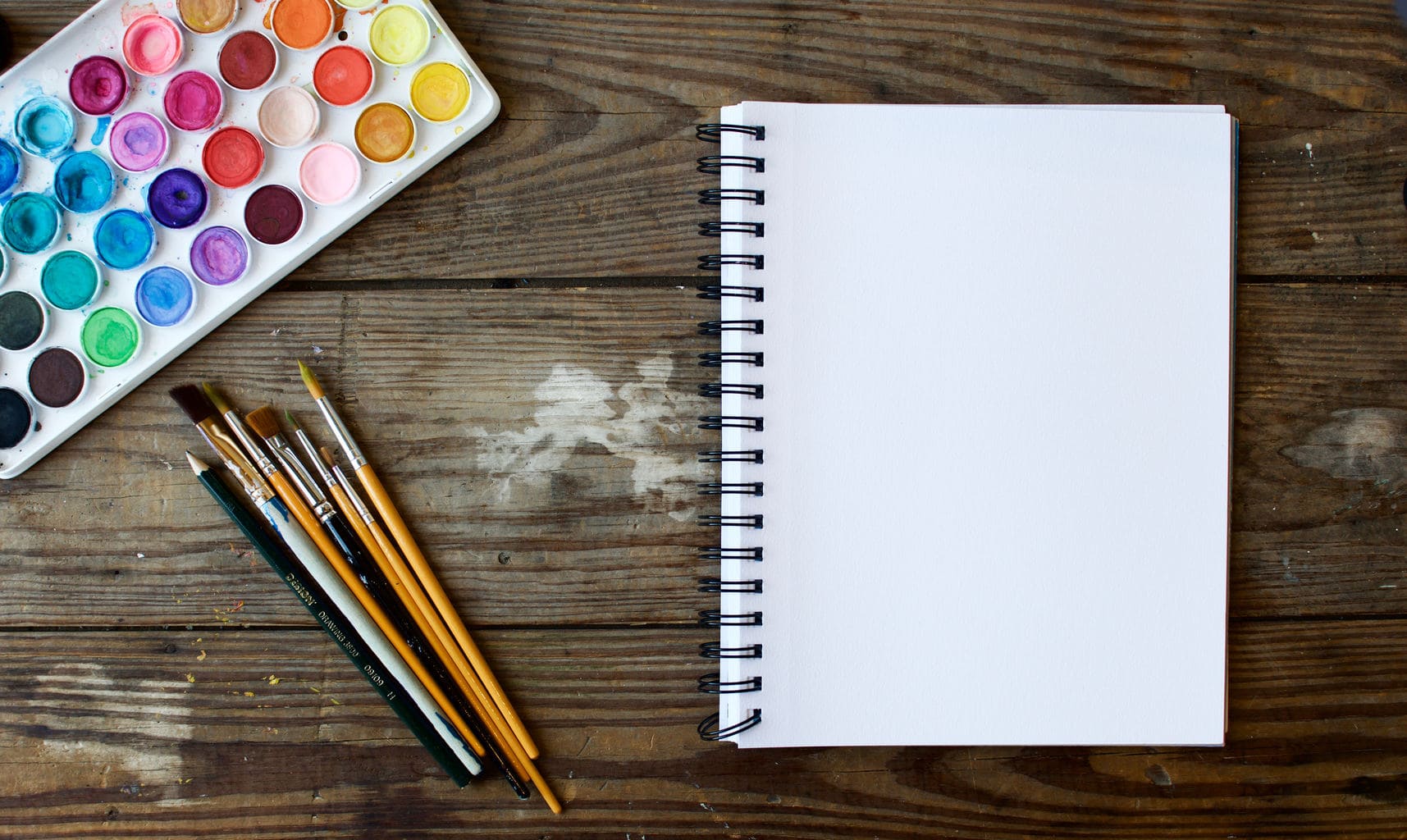 blank-notebook-with-colorful-paint-and-paint-brushes