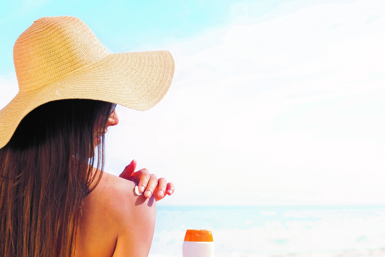 Brunette in Sun Hat Applying Sunscreen