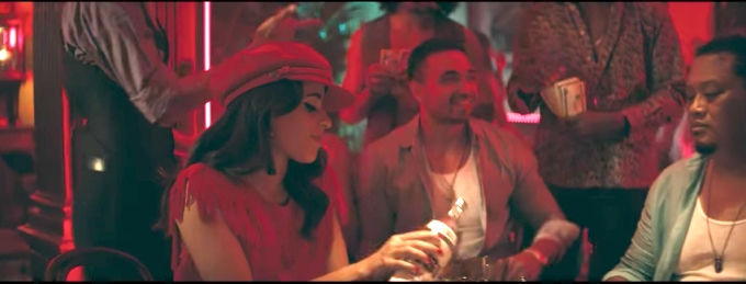 Camila Cabello in her Havana music video wearing a red dress and red hat in the club