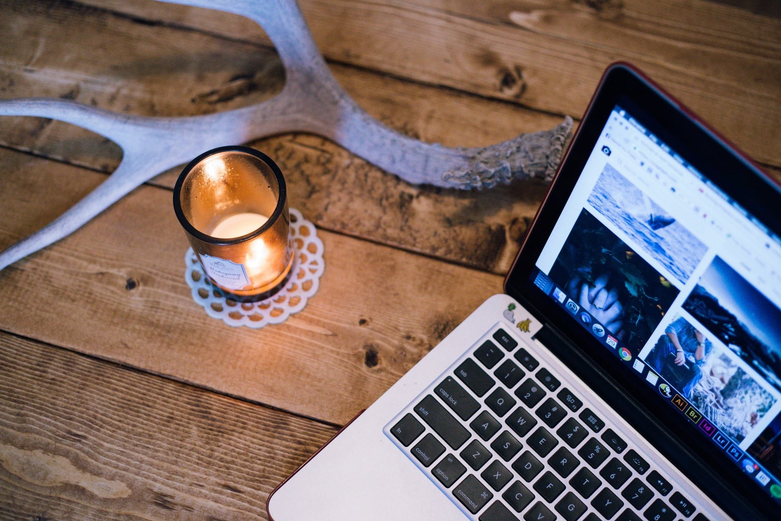 Candle burning next to a laptop