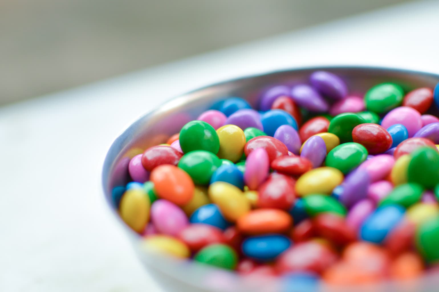 A bowl of colorful, round pieces of candy.