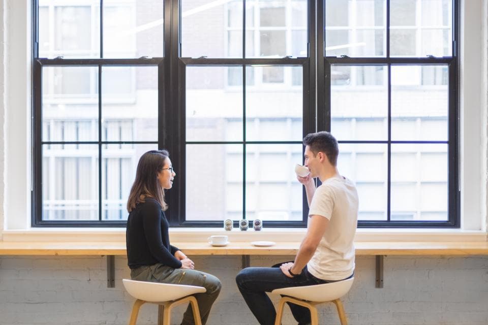 Man and woman in the city drinking coffee at a bar