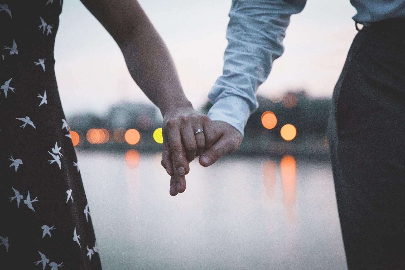 Close-up from behind of a young couple holding hands