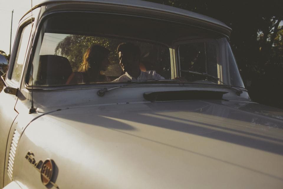 Couple sitting in white truck looking at each other