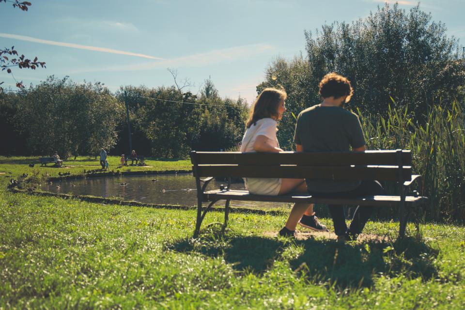 Man and woman sitting on a bench in the park