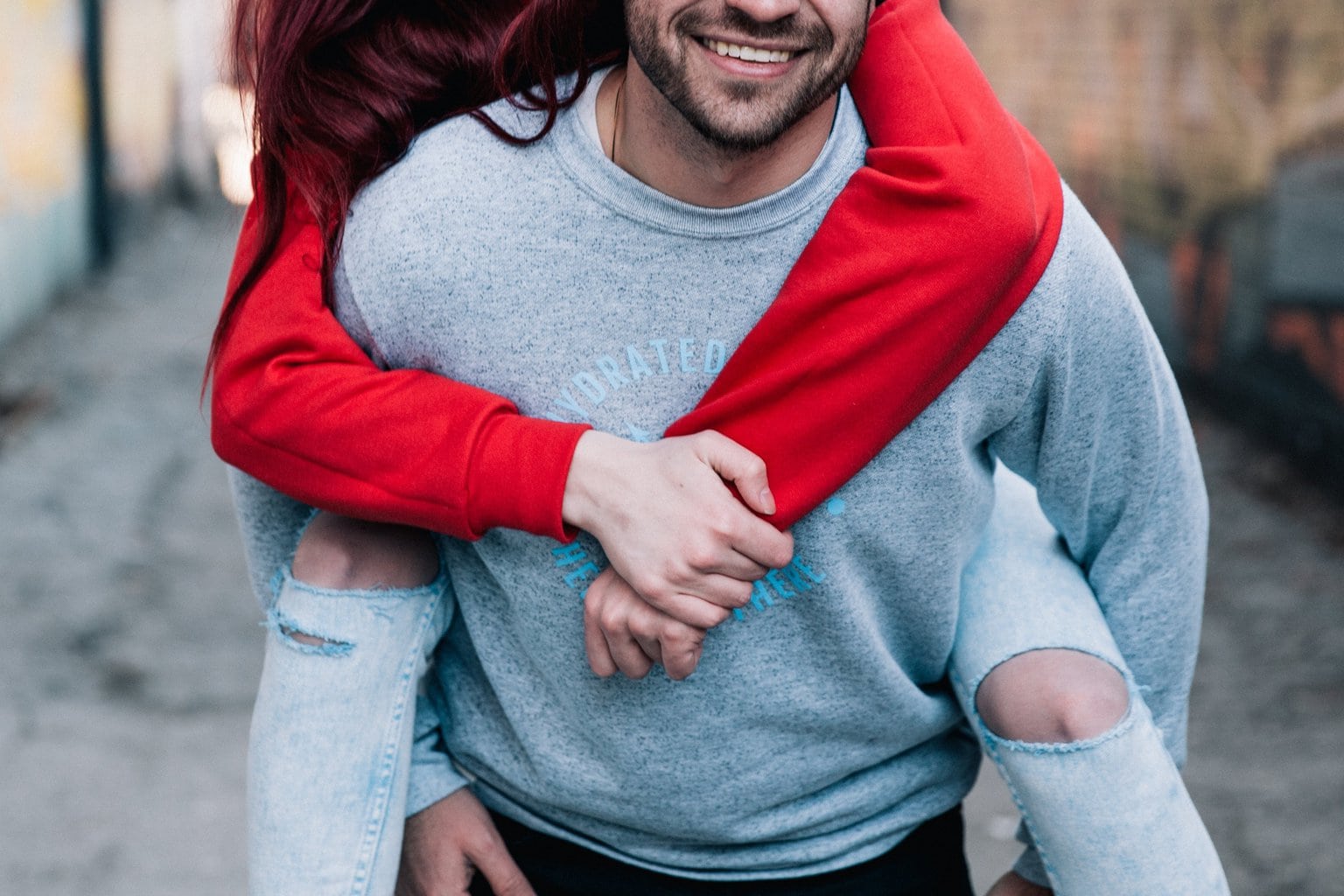 Photo of a couple on a date, with the boyfriend giving his girlfriend a piggyback ride