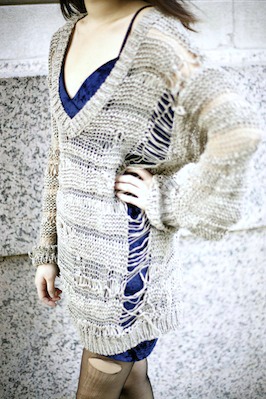Distressed sweater worn over velvet dress