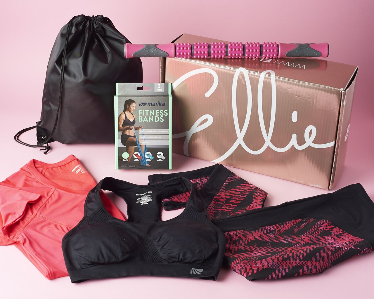 Ellie subscription box with various workout clothes surrounding it as well as a few fitness accessories.