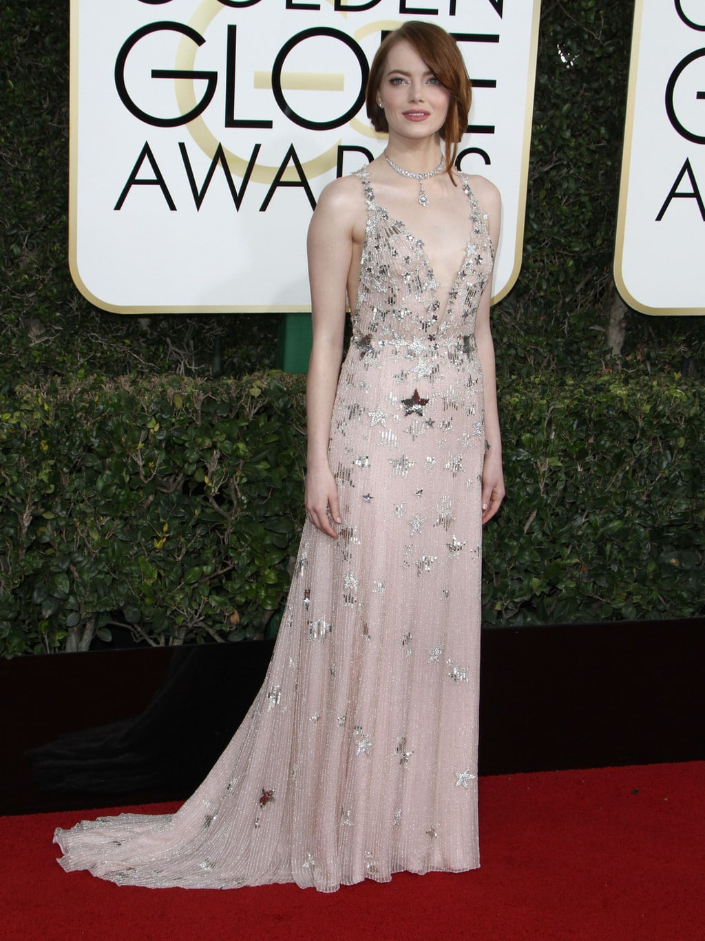 Emma Stone wearing a light pink Valentino gown with silver stars on the 2017 Golden Globes red carpet