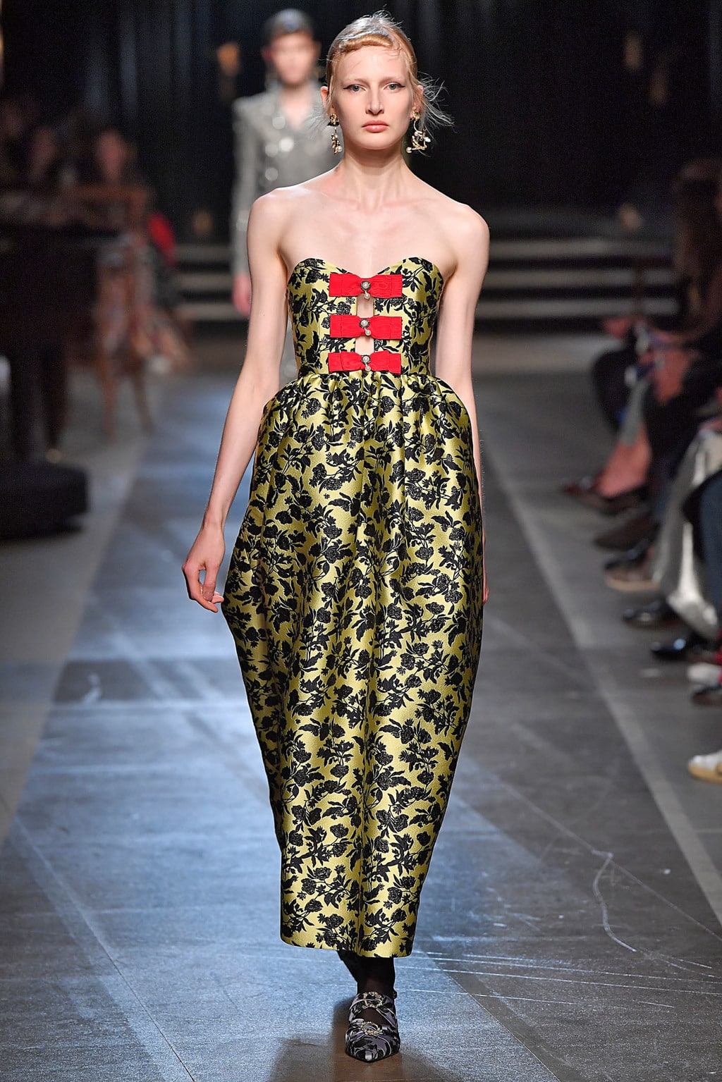 One look from Erdem's Spring 2018 Ready-to-Wear collection featuring a baroque-inspired strapless, gold and black dress.