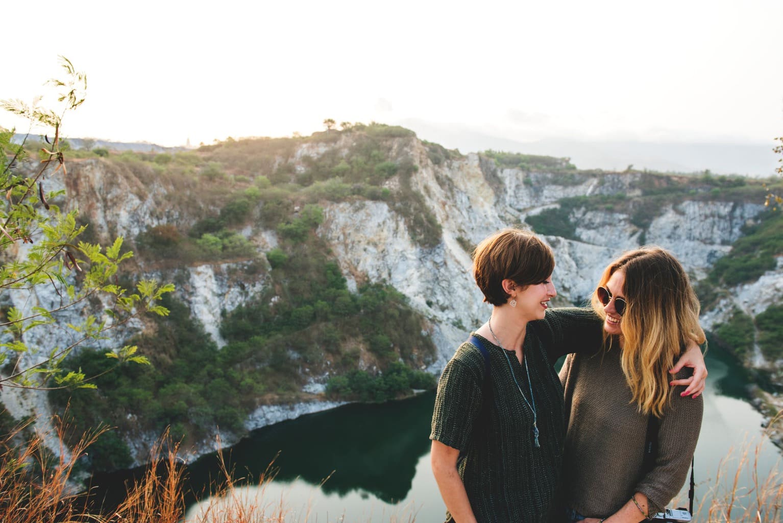 Two woman on a cliff with their arms wrapped around each other