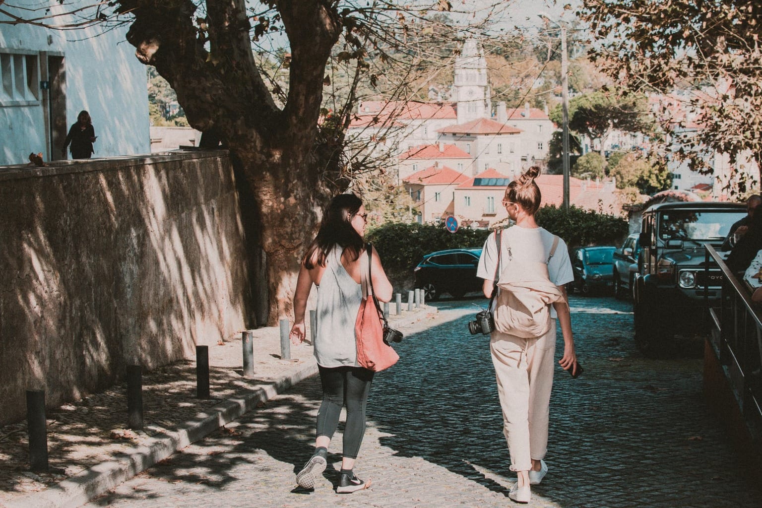 Two girls walking down the street with bags