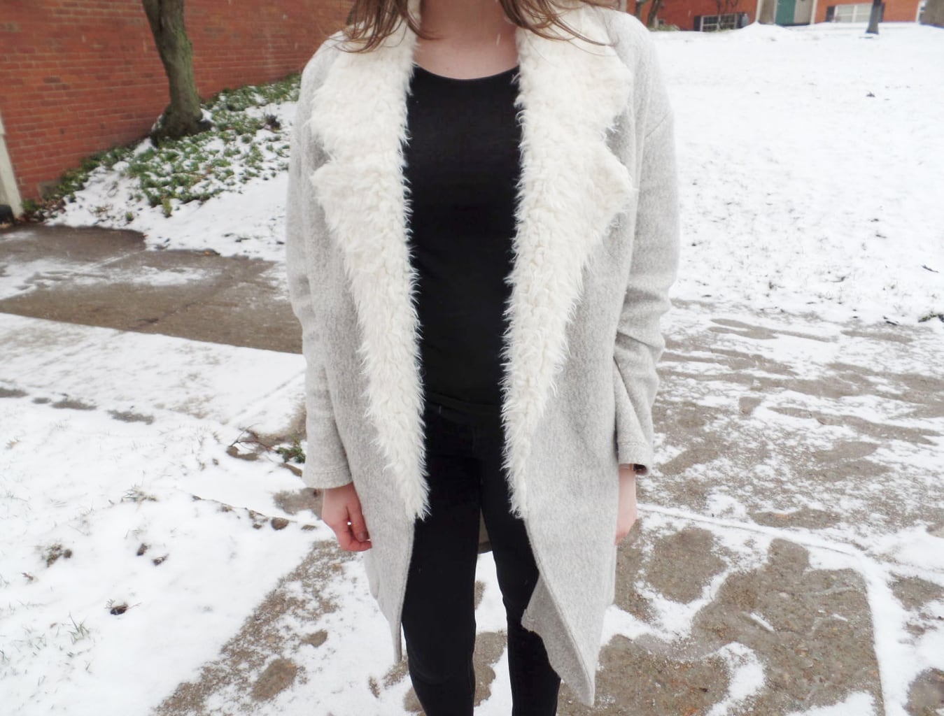 Mercyhurst University student Chloe wears a light grey longline coat with white fur lapels with her all black outfit.