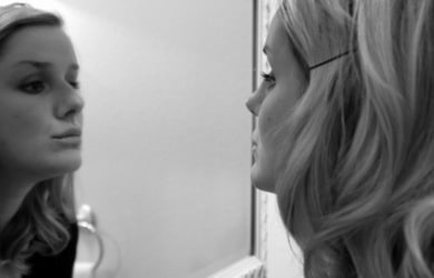 A girl getting ready in the mirror