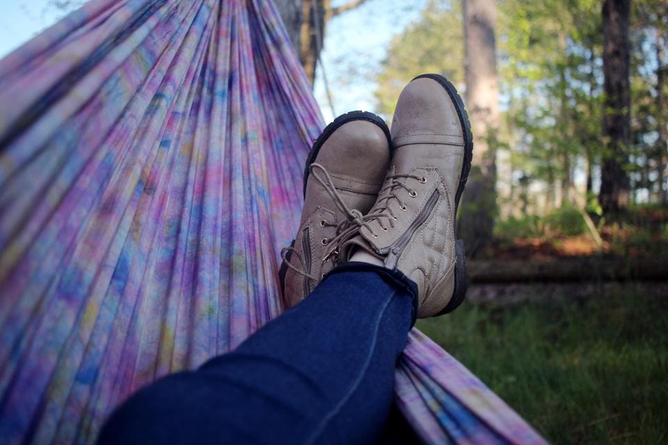 Girl relaxing with boots in a hammock