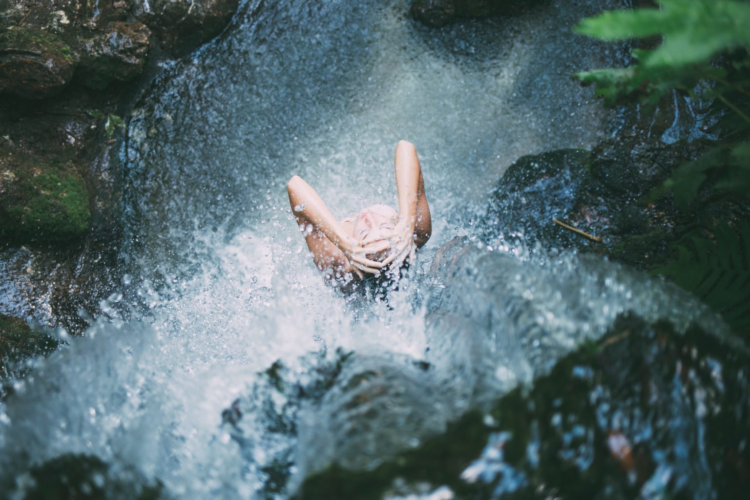 Girl showering in a waterfall