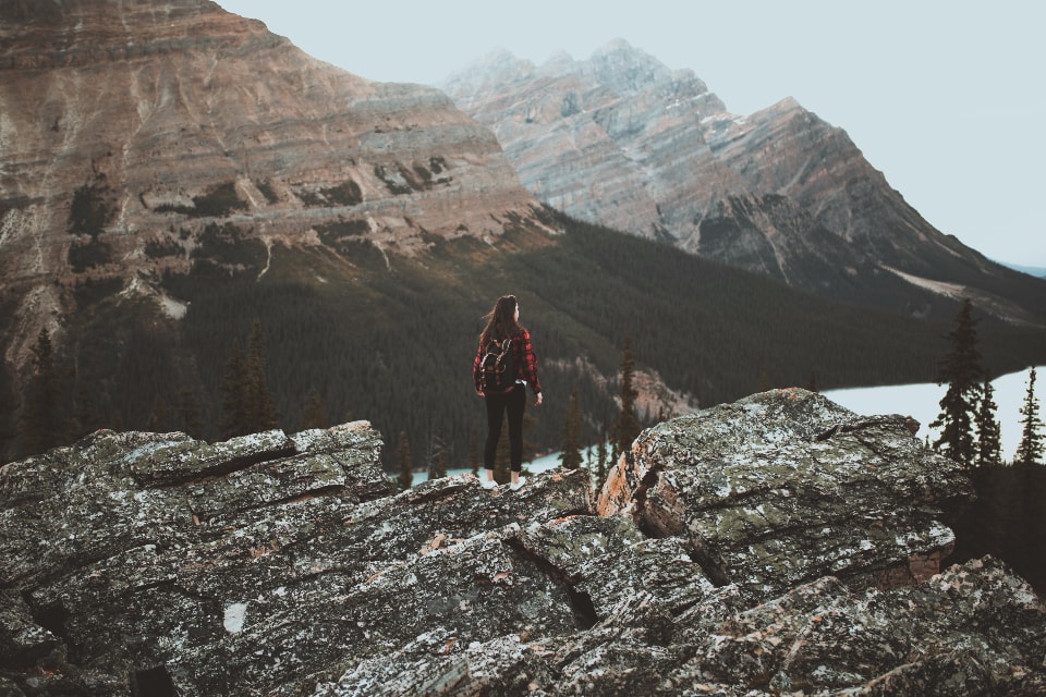 Brunette girl standing on the top of a snowy mountain