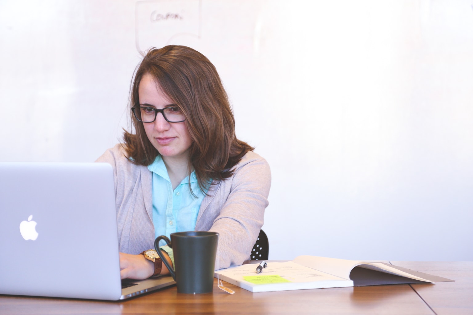 Girl wearing glasses typing on a laptop