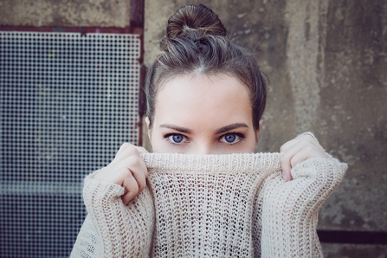 Girl with Bun Hiding Behind Her Sweater