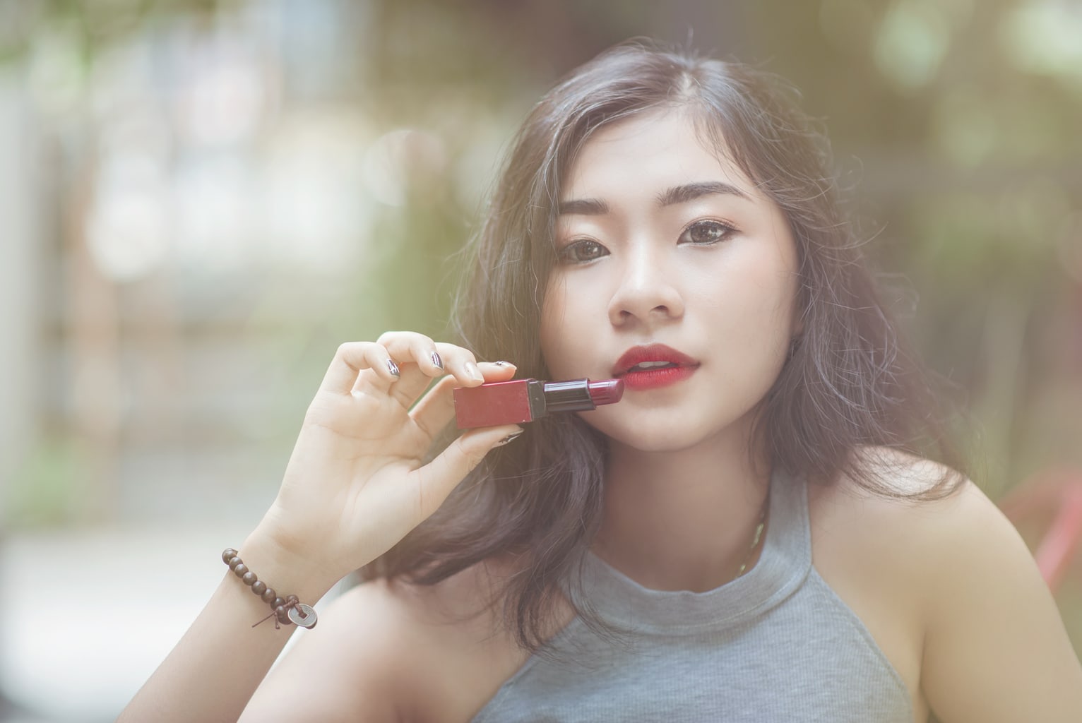 Girl holding a lipstick up to her mouth: Day to night makeup guide for students