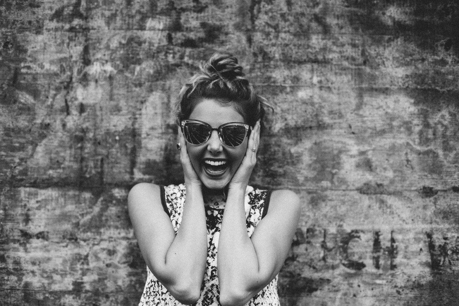 Happy girl holding her face and wearing sunglasses