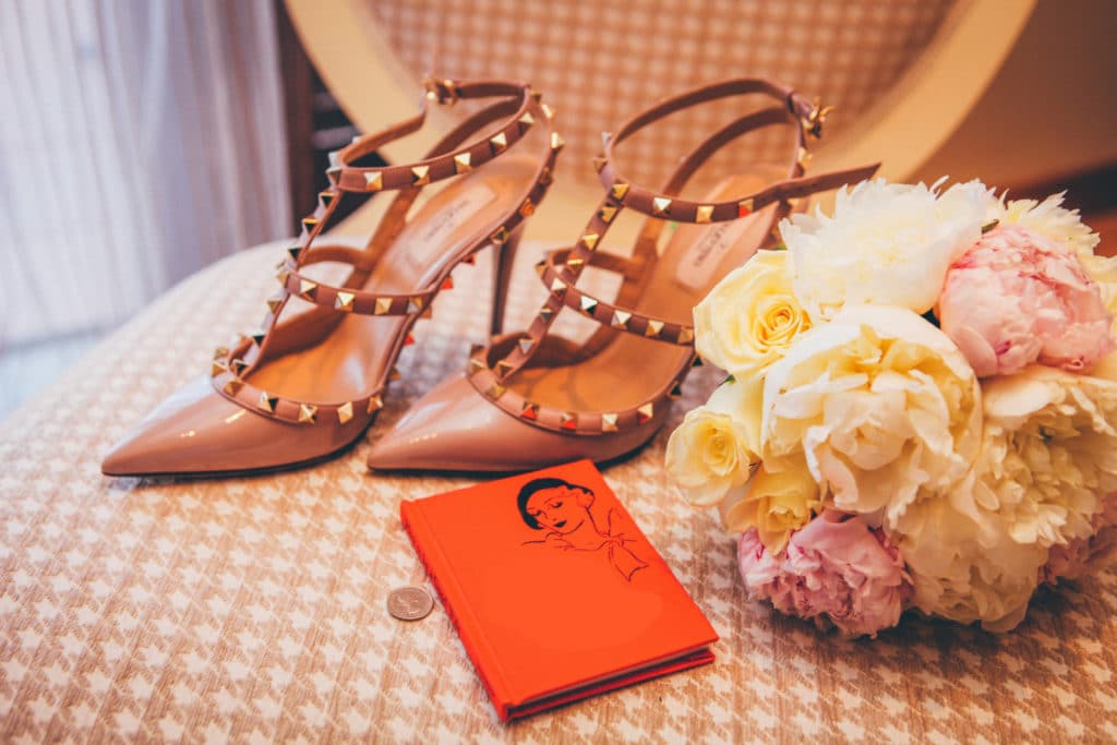 High heels on a table with a bouquet and a journal