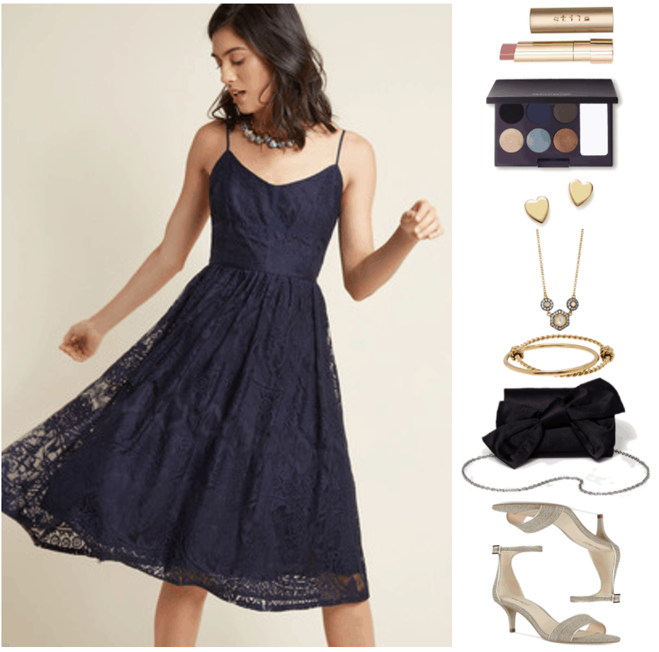 "How to Wear Kitten Heels--Without Looking Frumpy of Juvenile" Outfit #2 featuring navy blue lace spaghetti-strap fit-and-flare midi dress, stila color balm lipstick in "Misty," a pale pink shade; Laura Mercier Intense Clays Editorial Eye Palette, gold heart stud earrings, gold and black rhodium necklace with small clear stones surrounding ivory mother-of-pearl, gold twisted, knotted bangle bracelet attached to gold smooth bangle bracelet, black bow clutch with silver chain strap, pale gold kitten heel sandals with ankle strap