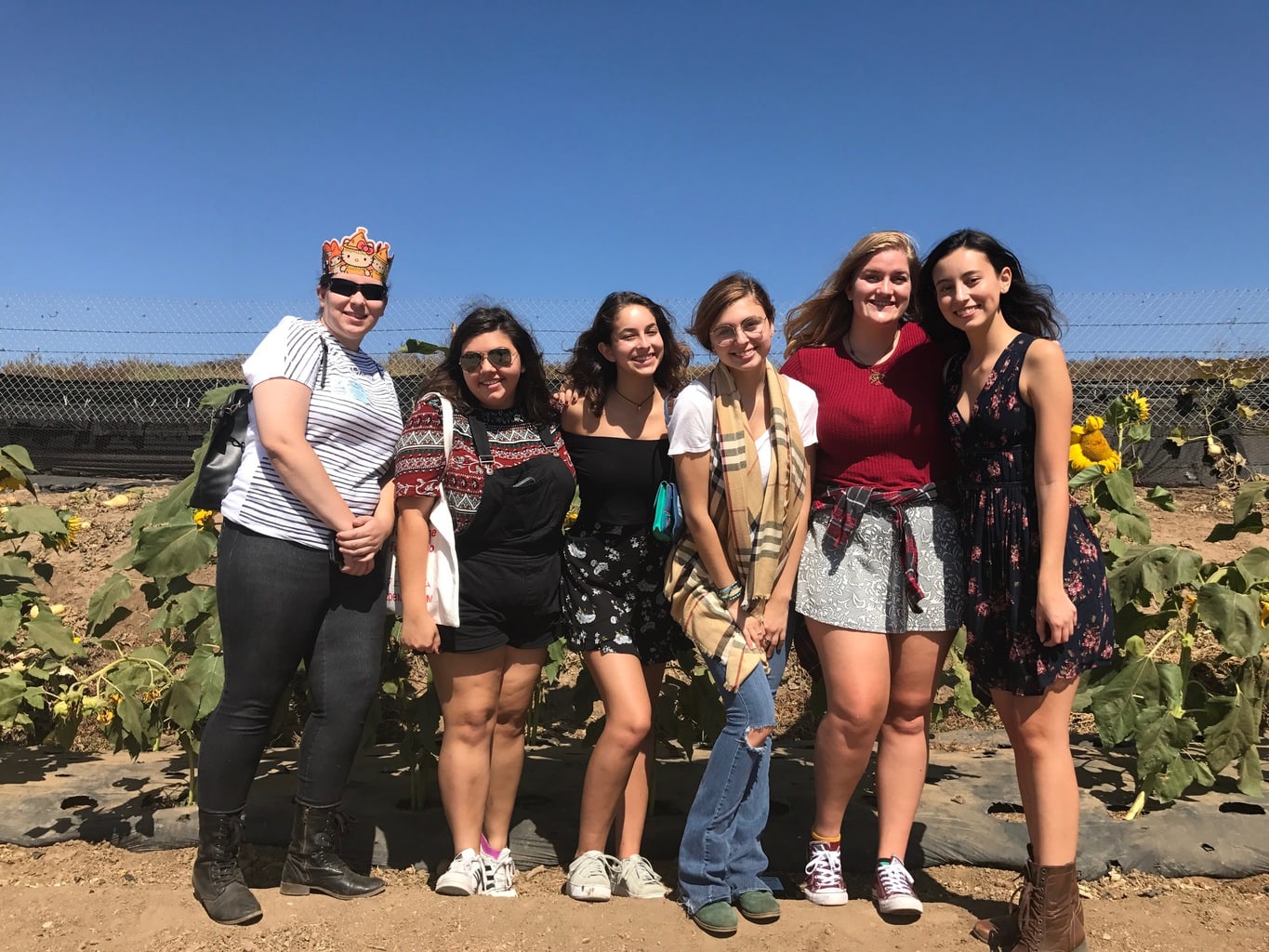 Friends standing with sunflowers in the background