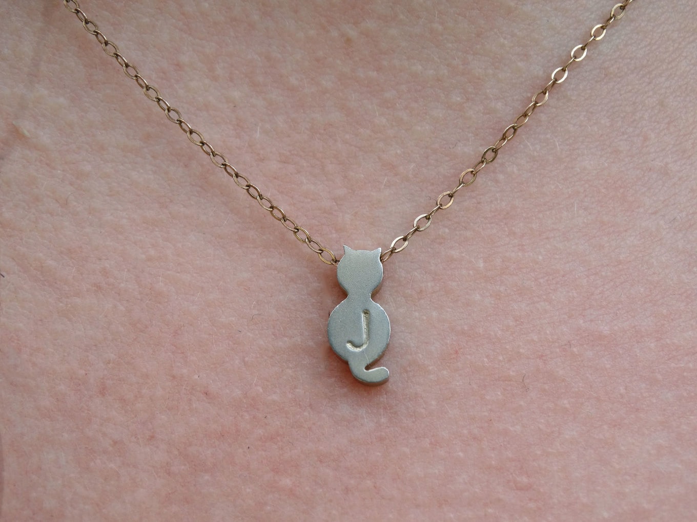 Cat necklace with a J on it