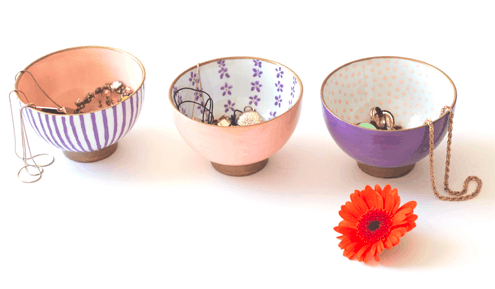 Photo of three printed bowls with jewelry in them and an orange flower in front of them.