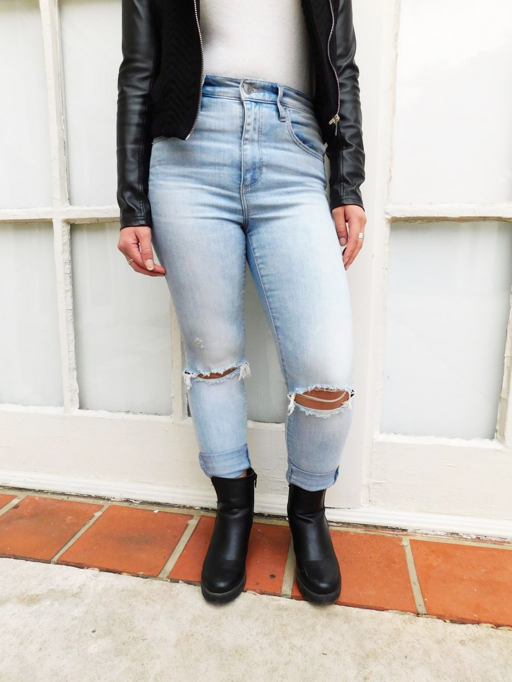 Fashion at Jefferson University: Jackie wears high-waisted, light-wash denim jeans with a white turtleneck tucked in. These jeans have distressed knees and are worn cuffed.