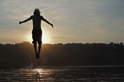 Guy jumping into a lake