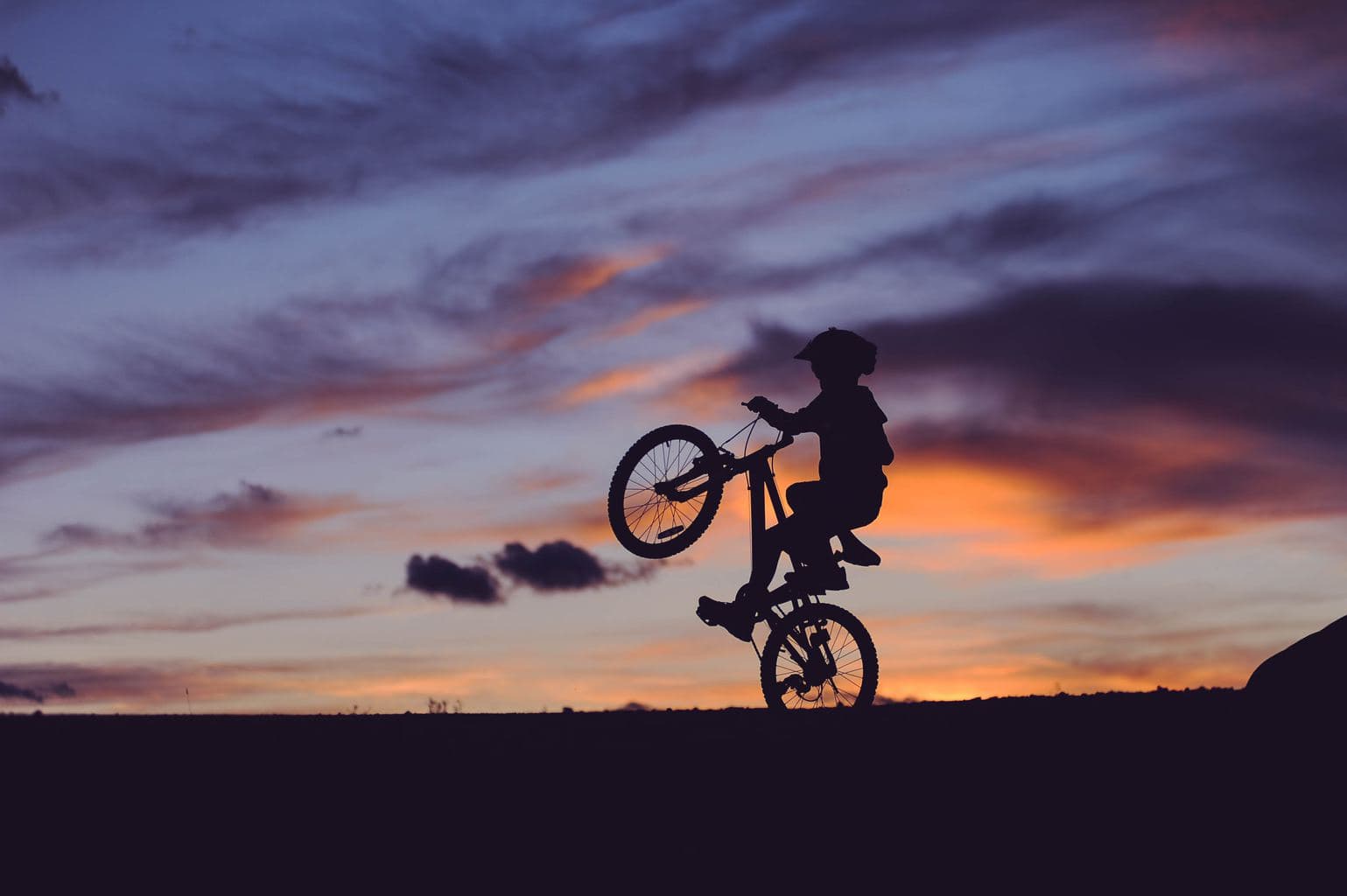 kid on bike with sunset