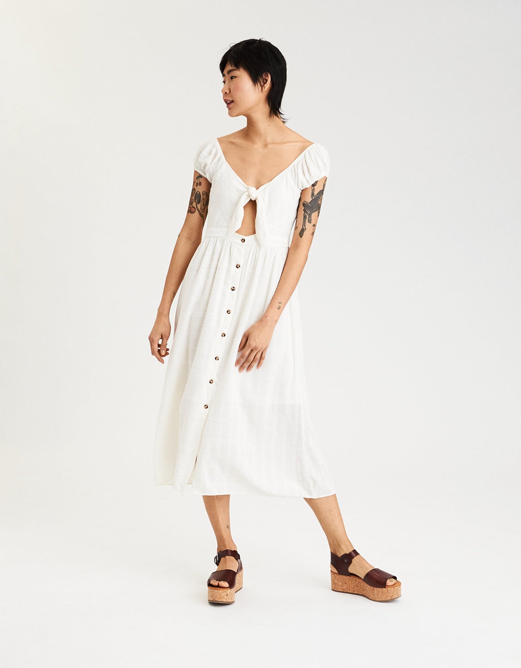 Photo of a model wearing a white knot front midi dress.