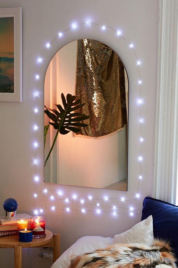 Christmas lights around a mirror - how to decorate your dorm with Christmas lights - lights on wall in bedroom