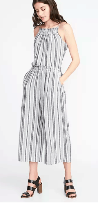 Photo of a girl with wavy hair wearing a striped jumpsuit with block heels.