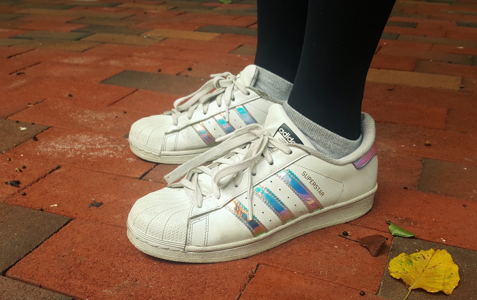 Alema's vintage-style white Adidas have holographic panels and rubber toes.