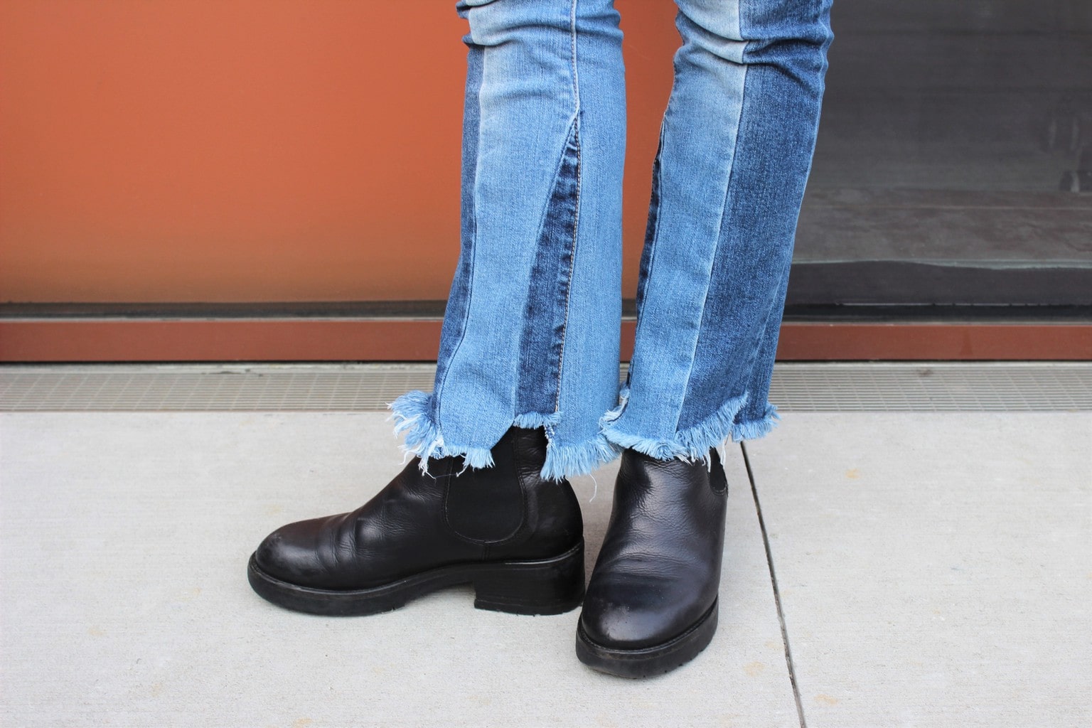 Raw-edge patchwork denim jeans with chunky black boots.