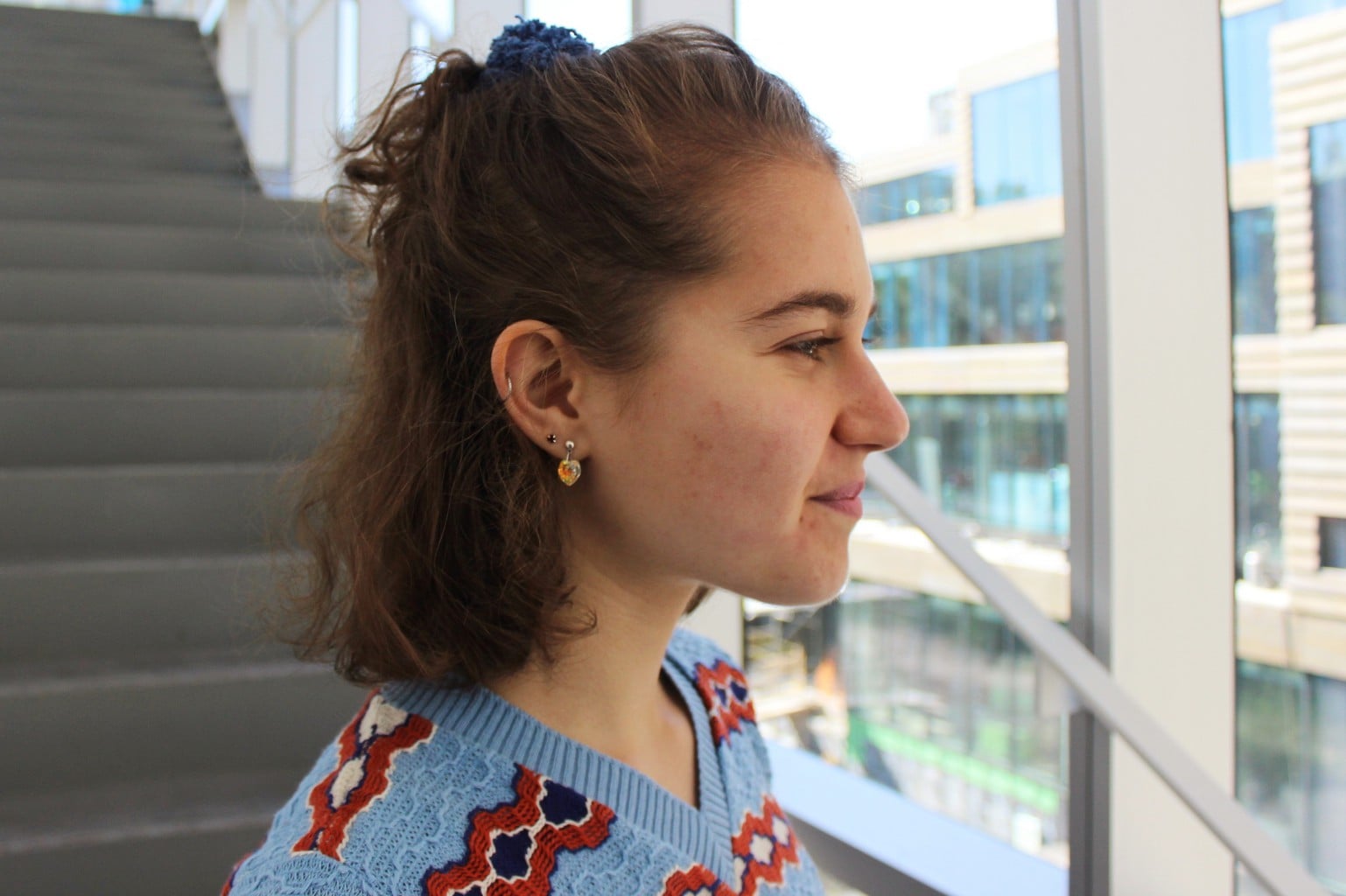 Hannah's pulled-back hair shows her multiple jeweled earrings.