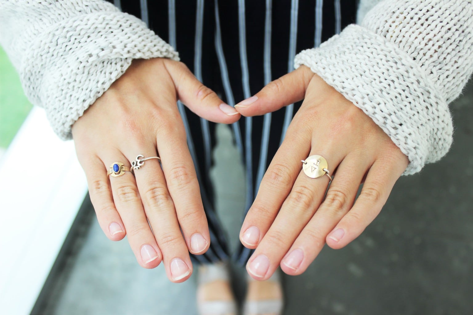 Barnard College student shows off her delicate gold rings and loose-knit white sweater.